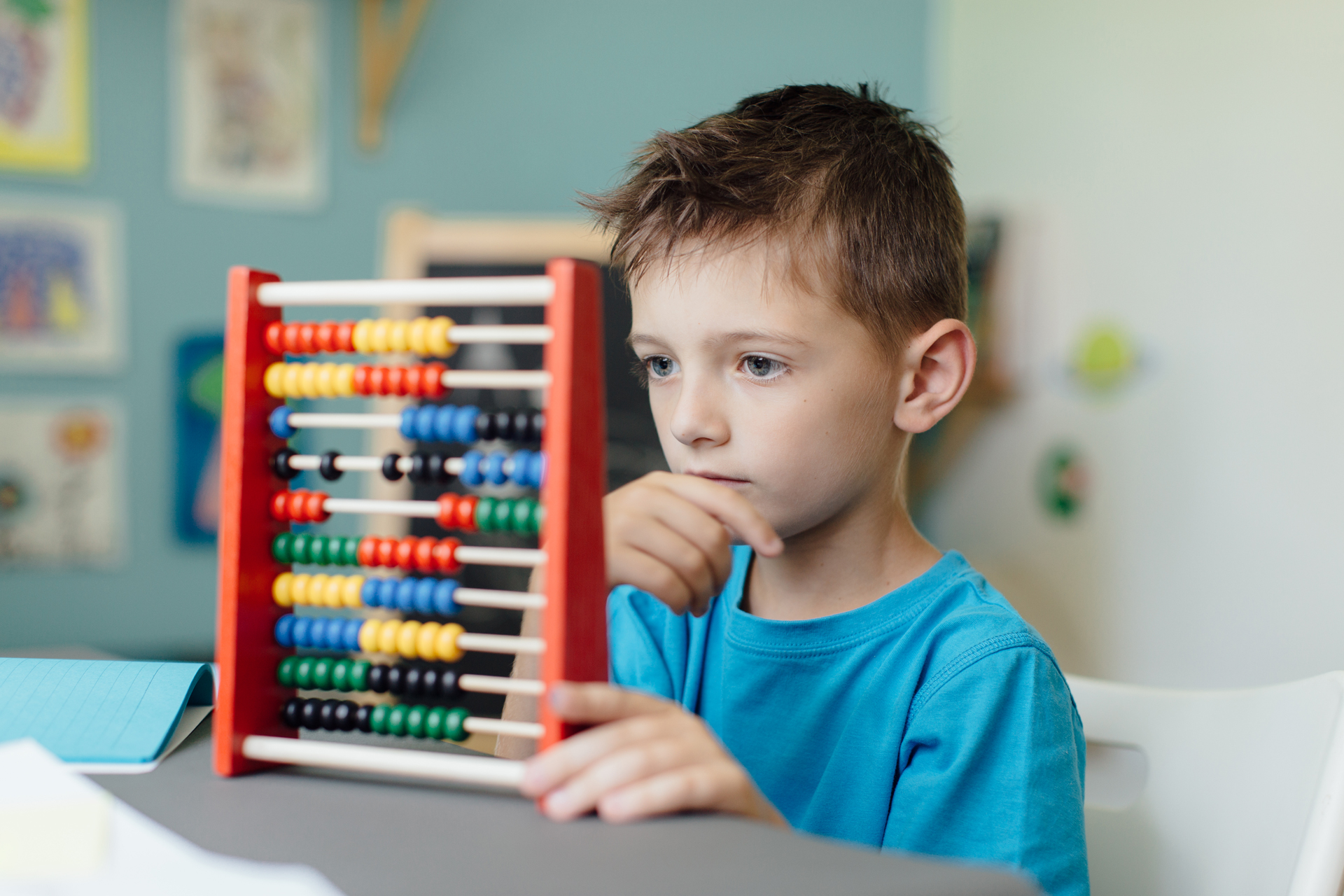 Thinking schoolboy learning maths with an abacus